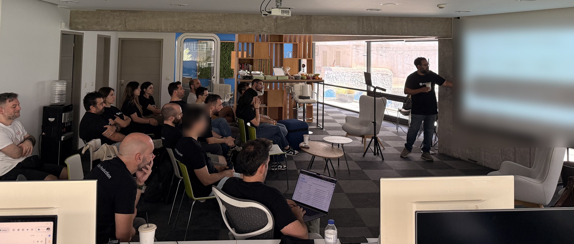 The team together in Athens, with CTO Panagiotis Moustafellos presenting at the front of the room.